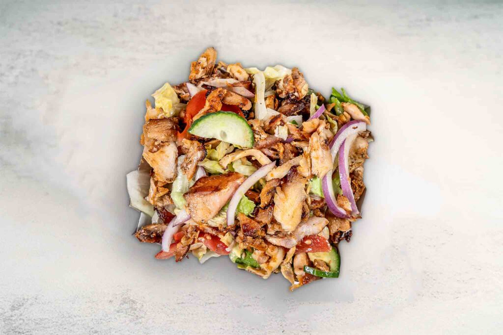 Fresh chicken salad with crisp lettuce, tomatoes, red onion, cucumber, and light dressing for a healthy, satisfying meal.
