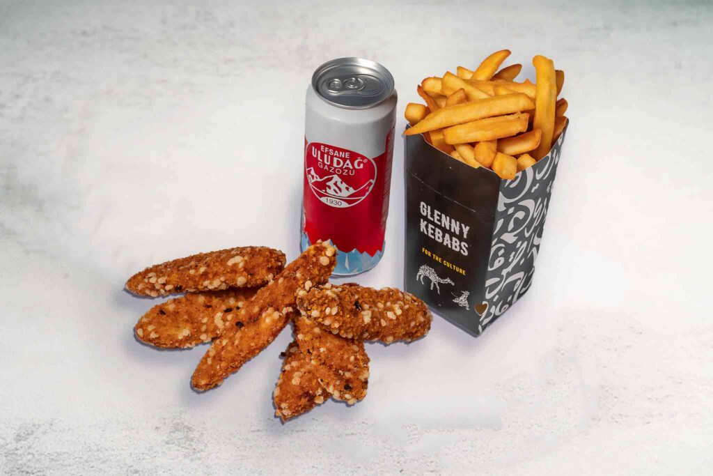 Image of 3 crispy chicken tenders, seasoned chips, and a soft drink can, highlighting the crispy coating, juicy interior, and golden chips.