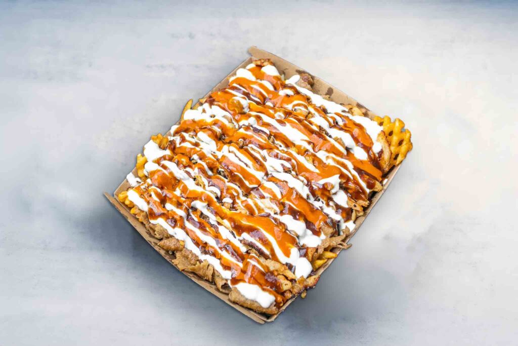 Large Halal Snack Pack featuring golden fries, mozzarella cheese, generous portions of lamb, chicken, or mixed meat, finished with a variety of sauces.