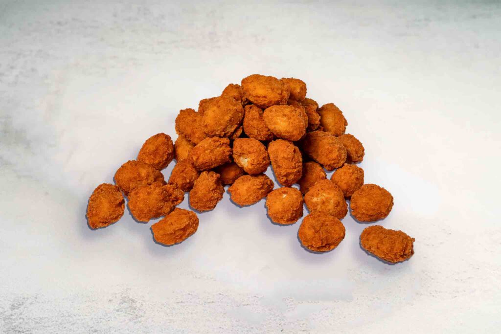 A plate of crispy, golden fried popcorn chicken pieces, perfect for dipping and enjoying as a snack or meal.