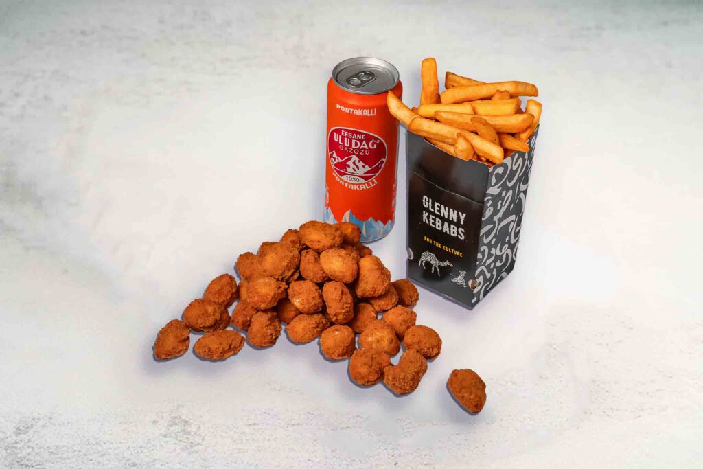 A delicious meal featuring crispy fried popcorn chicken, seasoned regular chips, and a can of soft drink, served together in a satisfying combo.